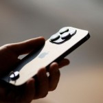 Ilustrasi seseorang memegang iPhone 14 di Apple store Beijing, China, (16/9/2022). REUTERS/Thomas Peter/File Photo.-1674447854