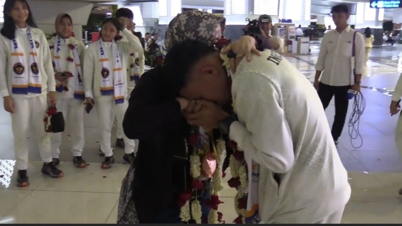 Manajer Rosi Nurasjati sambil menangis memeluk erat atlet Ryan Jefri Hamonangan Lumbanbatu saat penyambutan Timnas Kickoxing Indonesia di Bandara Soekarno-Hatta