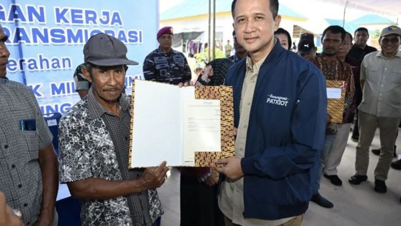 Menteri Transmigrasi Muhammad Iftitah Sulaiman Suryanagara (kanan) menyerahkan Sertifikat Hak Milik (SHM) kepada warga transmigran. (Antara)