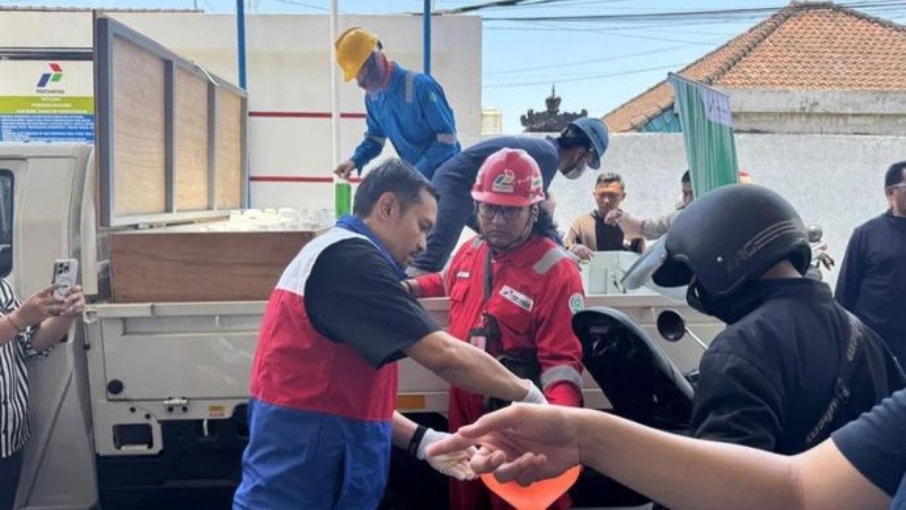 Petugas menyalurkan BBM menggunakan jeriken kepada konsumen untuk mempercepat pemulihan antrean di salah satu SPBU di Denpasar, Bali, Jumat, 16 Oktober 2026 (Antara)